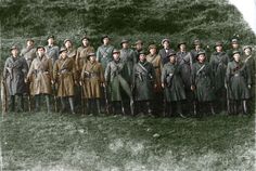 an old photo of men in trench coats and hats posing for a group photograph together