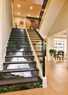 the stairs are painted with green trees and blue water in this modern home entryway