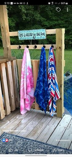 towels are hanging on the back of a wooden bench