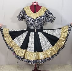 24 KARAT COLLECTION     "  Pentagon " New , women's square dance outfit. It has a v neck blouse with a gold lame ruffle and elastic sleeves. The skirt is very full and has a double ruffle. There are 16 alternating panels . Gold, black and white have been used in the fabric.      This is a One of a Kind creation, never to be made again. It is a size LARGE . It has a waistband from 30" -39" and the skirt length is 23". It is an ample fit. A FREE matching man's tie is included , not the belt. Gold, Square Dance Outfit, Elastic Sleeves, Square Dance, Dance Outfit, Belt Gold, Gold Lame, Square Dancing, Plain Fabric, Outfit Dress