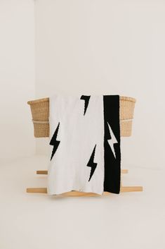 a black and white blanket sitting on top of a wooden stand