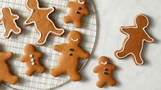 several ginger cookies on a cooling rack with one cookie cut out to look like people