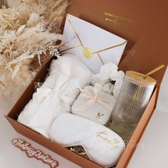 an open box with some white items in it next to a vase and other things