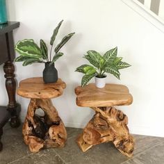 two wooden stools sitting next to each other on top of a stone floor near a stair case