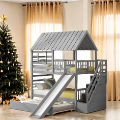 a bunk bed with a slide next to a christmas tree