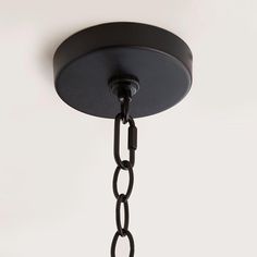 a black chandelier hanging from the ceiling with a light bulb on it's side