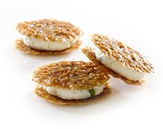 three crackers with food on them sitting next to each other in front of a white background