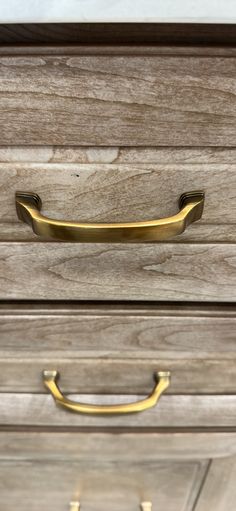 a close up of a drawer with brass handles