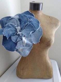 a mannequin head with a blue flower on it