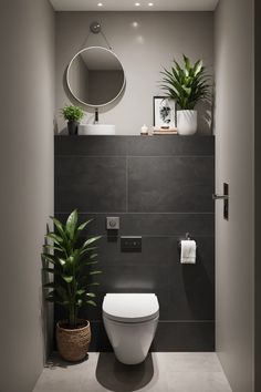 a bathroom with a toilet, mirror and plants