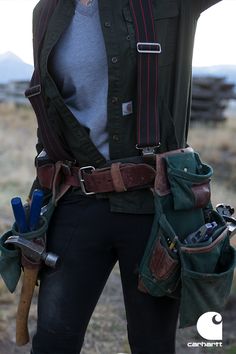 a woman wearing an army uniform and carrying tools