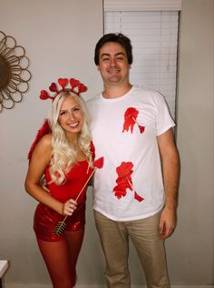 a man standing next to a woman in a red dress and white t - shirt