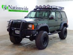 a green jeep parked in front of a nation wide sign