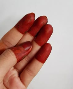 a person with red nail polish on their fingers