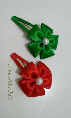 two red and green hair bows with pearls on each side, sitting next to each other