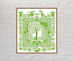 a cross stitch pattern on a white brick wall with a green tree in the center