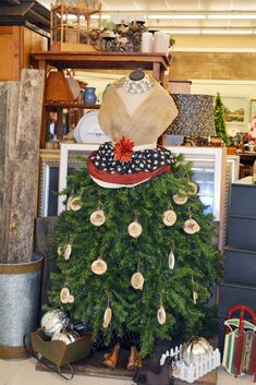 a christmas tree with hats on top in a room filled with boxes and other items