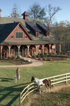 two horses standing in front of a large house