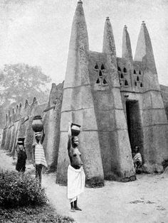 an old black and white photo of people standing in front of some large stone structures