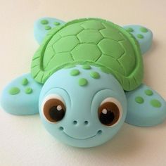 a close up of a small toy turtle on a white surface with one eye open