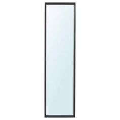 a tall black and white mirror sitting on top of a wall