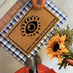 a person standing next to a door mat with an eye on it