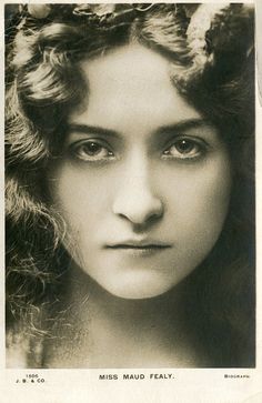 an old black and white photo of a woman with curly hair wearing a wreath of flowers on her head