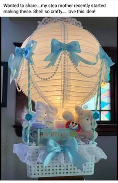 a baby shower basket with teddy bears in it and a light up balloon above it