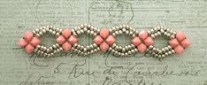 three pieces of pink beaded bracelets on top of a piece of old paper