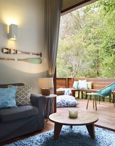 a living room filled with furniture next to a wooden floor covered in blue rugs