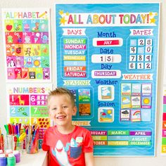 a young boy standing in front of a bulletin board with calendars and markers on it