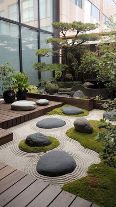 a japanese garden with rocks and grass in the center, surrounded by wooden decking