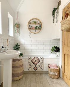 a bathroom with white tile and wooden floors