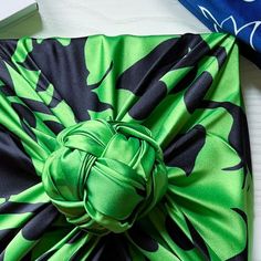 a green and black tie on top of a table