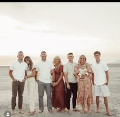 a group of people standing next to each other on a beach