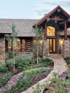 a stone and wood house is shown in the evening