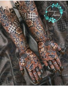 two hands with henna tattoos on them