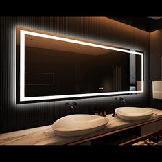 a bathroom with two sinks and a large mirror in it's center, all lit up by lights