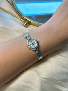 This exquisite vintage Baylor ladies watch showcases a timeless silver tone finish with a beautifully detailed textured bracelet and an elegant oval case. The intricate silver dial is adorned with delicate patterns, adding a touch of grace to this classic timepiece. Powered by a reliable mechanical movement, this watch runs and keeps time accurately. The case size is approximately 16.2mm, and it fits comfortably on a wrist size of up to 15.25cm. Please note the watch has minor cosmetic imperfect Silver Watch For Ladies, Silver Vintage Watch, Textured Bracelet, Vintage Character, Mechanical Movement, Women Wrist Watch, Ladies Watch, Wrist Watches, Silver Watch