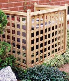 a wooden planter sitting in the middle of a garden next to a brick wall