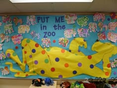 a bulletin board that says put me in the zoo with stuffed animals and toys on it