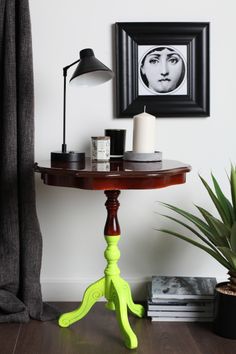 a table with a lamp and pictures on the wall