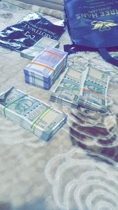 several stacks of money sitting on top of a bed