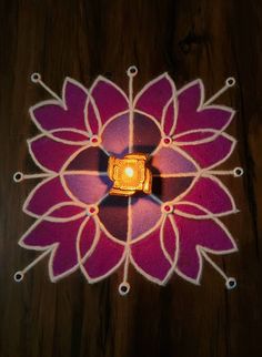 a lit up flower on top of a wooden table