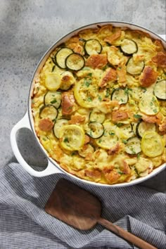 a casserole dish with zucchini, cheese and bread in it on a table