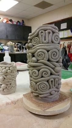 two vases sitting on top of a table in a room filled with other items