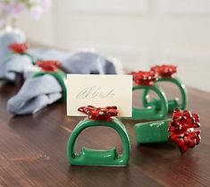 three green rings with red bows on them sitting on a table next to a note