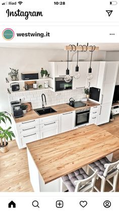 an instagram photo of a kitchen with white cabinets and wood counter tops