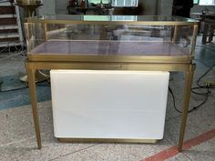 a gold and glass display case on the floor