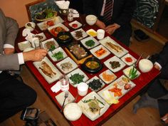 a group of people sitting around a table with food on it